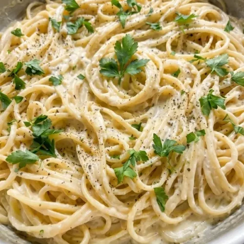 Creamy garlic parmesan pasta thickly coated in a rich, glossy cheese sauce and topped with freshly grated hard cheese.