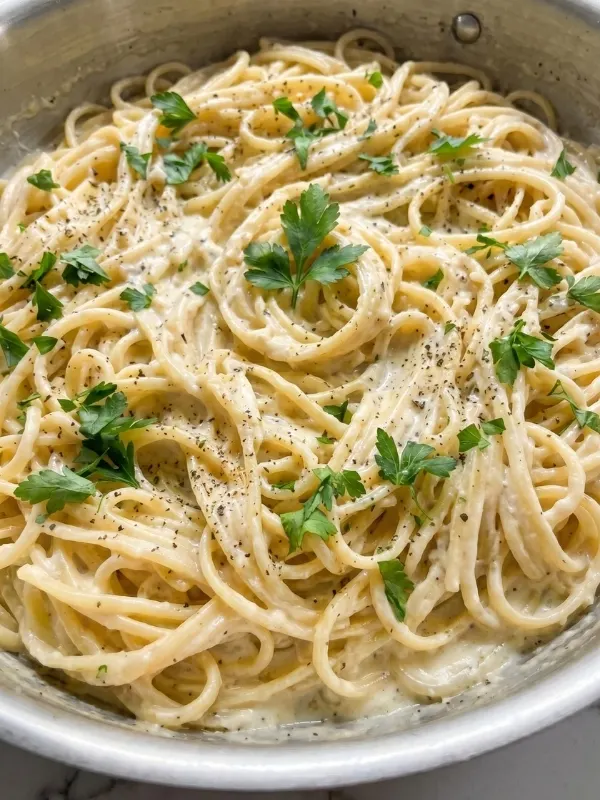 Creamy garlic parmesan pasta thickly coated in a rich, glossy cheese sauce and topped with freshly grated hard cheese.
