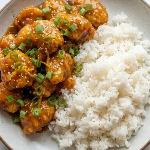 an-fried chicken chunks simmering fiercely in a thick, completely sticky homemade orange sauce loaded with fresh ginger and citrus zest.