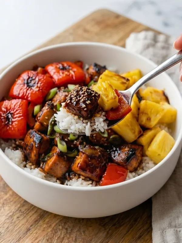 white ceramic bowl completely filled with fiercely steaming jasmine rice, aggressively topped with heavily charred chicken chunks, vibrant red bell peppers, and fresh pineapple all violently coated in a ridiculously sticky, dark brown sugar soy glaze.