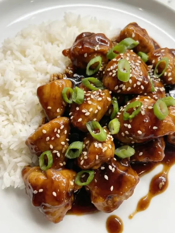 One-pan Mongolian chicken served with white jasmine rice on a plate, featuring tender chicken in a glossy savory sauce.